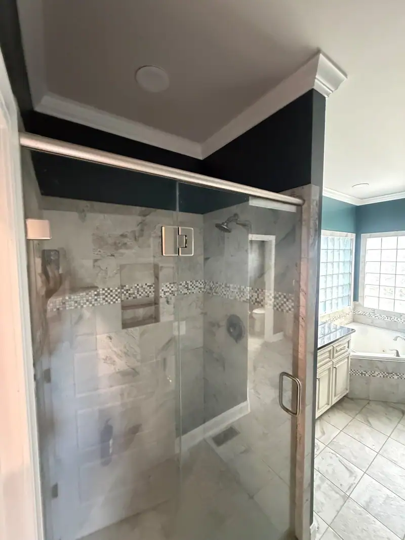 Finished tiled walk-in shower with a glass door