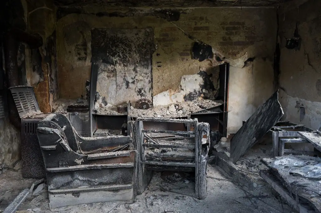 Living room after a fire, soot on the walls and a burnt sofa